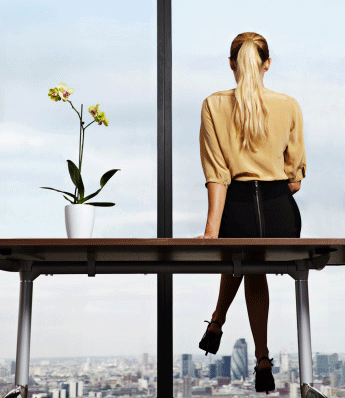 blonde-business-woman-in-office-looking-out-window-skyrise